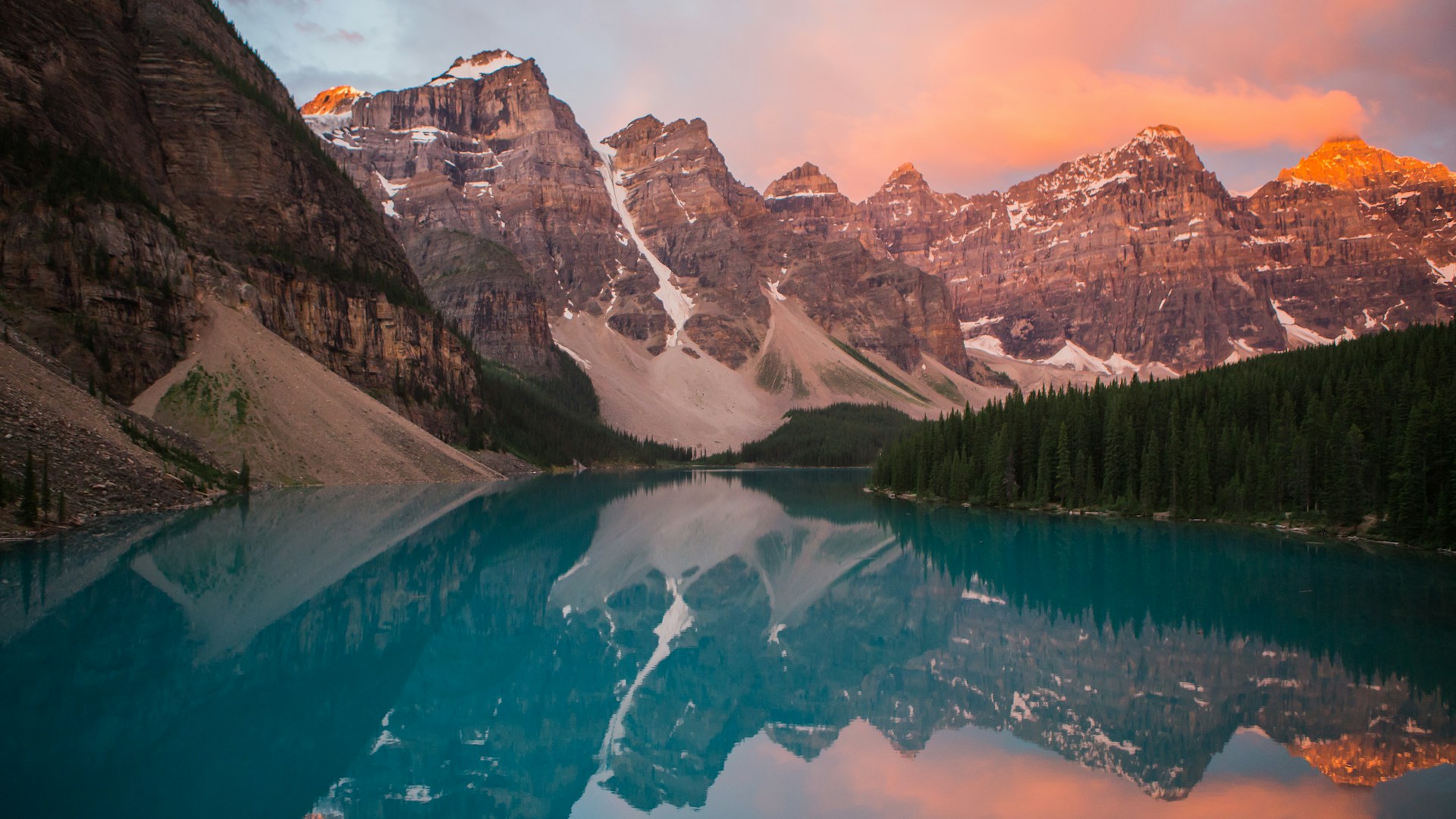 Scenic mountain lake surrounded by pine forests and snow peaks
